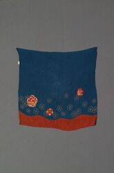 Crêpeweefsel in blauw en rood met een bedrukking met bloemmotieven en cirkels in kaki en goud