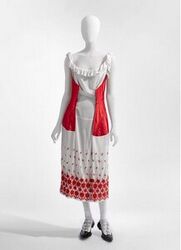 Japon in wit voile met ronde hals en armsgaten afgezet met gefronselde stroken; op de rok een boor...