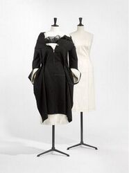 Strapless japon in ecru katoen met ritssluiting middenrug; op de naden zijn rijgsteken in zwart aa...