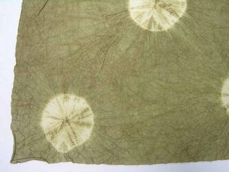 Handgeschept papier met ronde afbindmotieven in wit op een kakikleurige grond