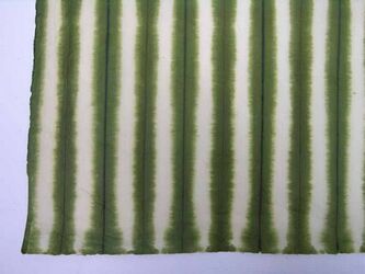 Handgeschept papier met vertkale afbindmotieven in wit op een groene grond