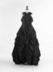 Lange rok in zwart katoen en viscose, versierd met ruches en gefronst aan verticale gebogen balein...