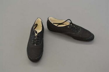 Paar zwart katoenen veterschoenen met geribbelde rubberen zolen; gevlochten zwarte katoenen veters...