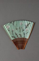 Waaier met een bamboe montuur met met ingekerfde bloemmotieven op de buitenbenen;lichtgroen papier...