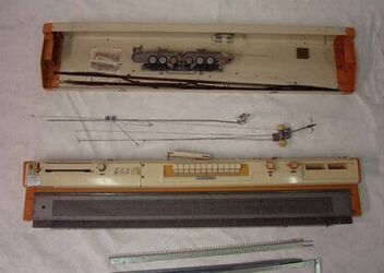 breimachine in doos; model met twee naaldenbedden en een mechanisme om de steken te verschuiven, v...